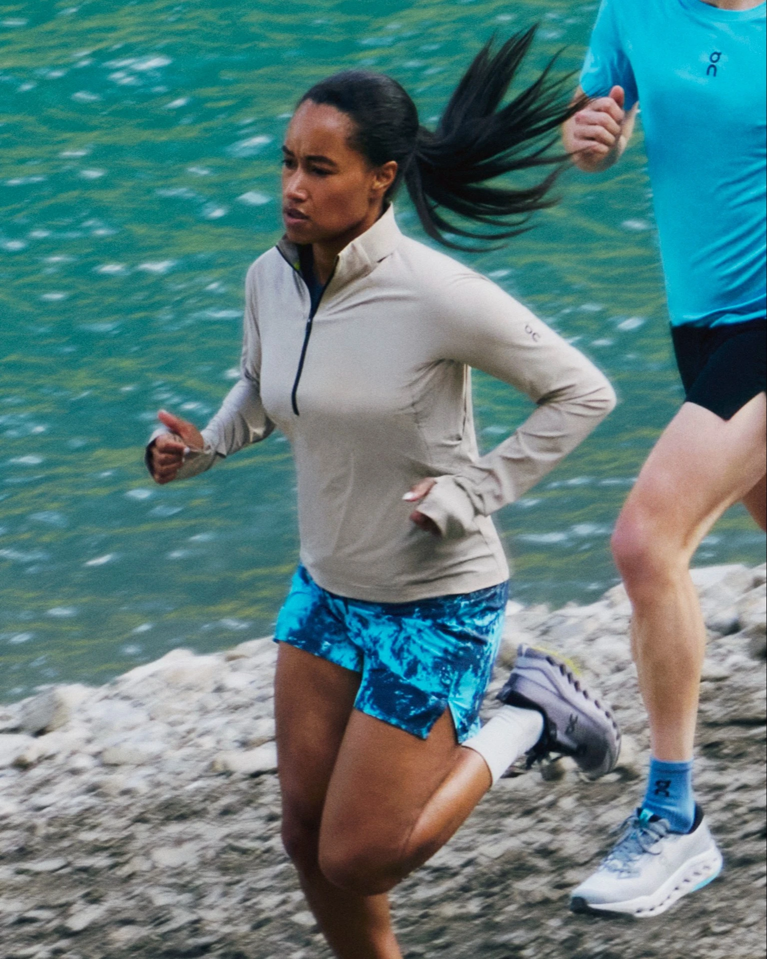 Zwei Läufer*innen laufen einem Ufer entlang.