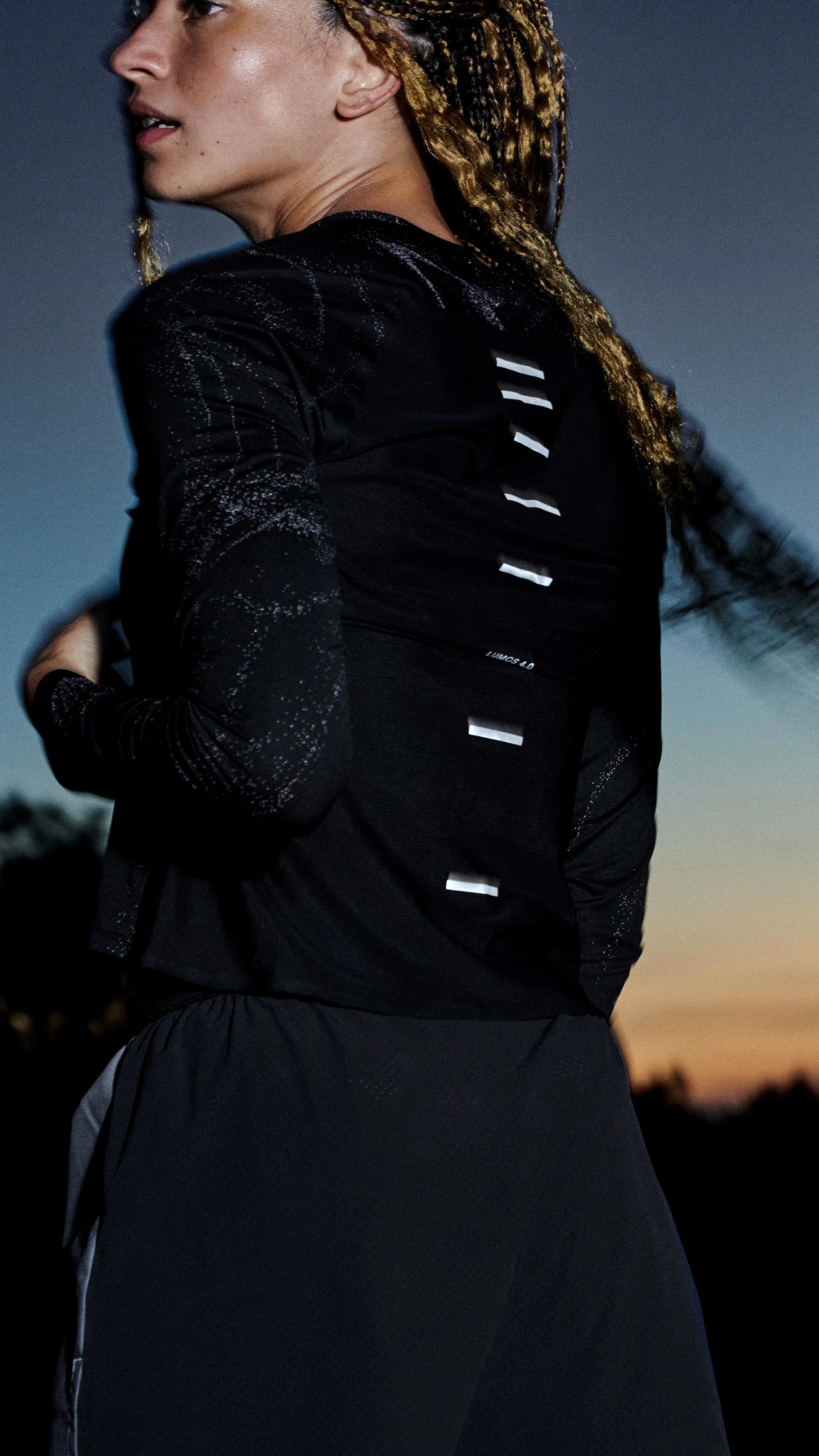 Two women standing outside showing their On apparel from behind.