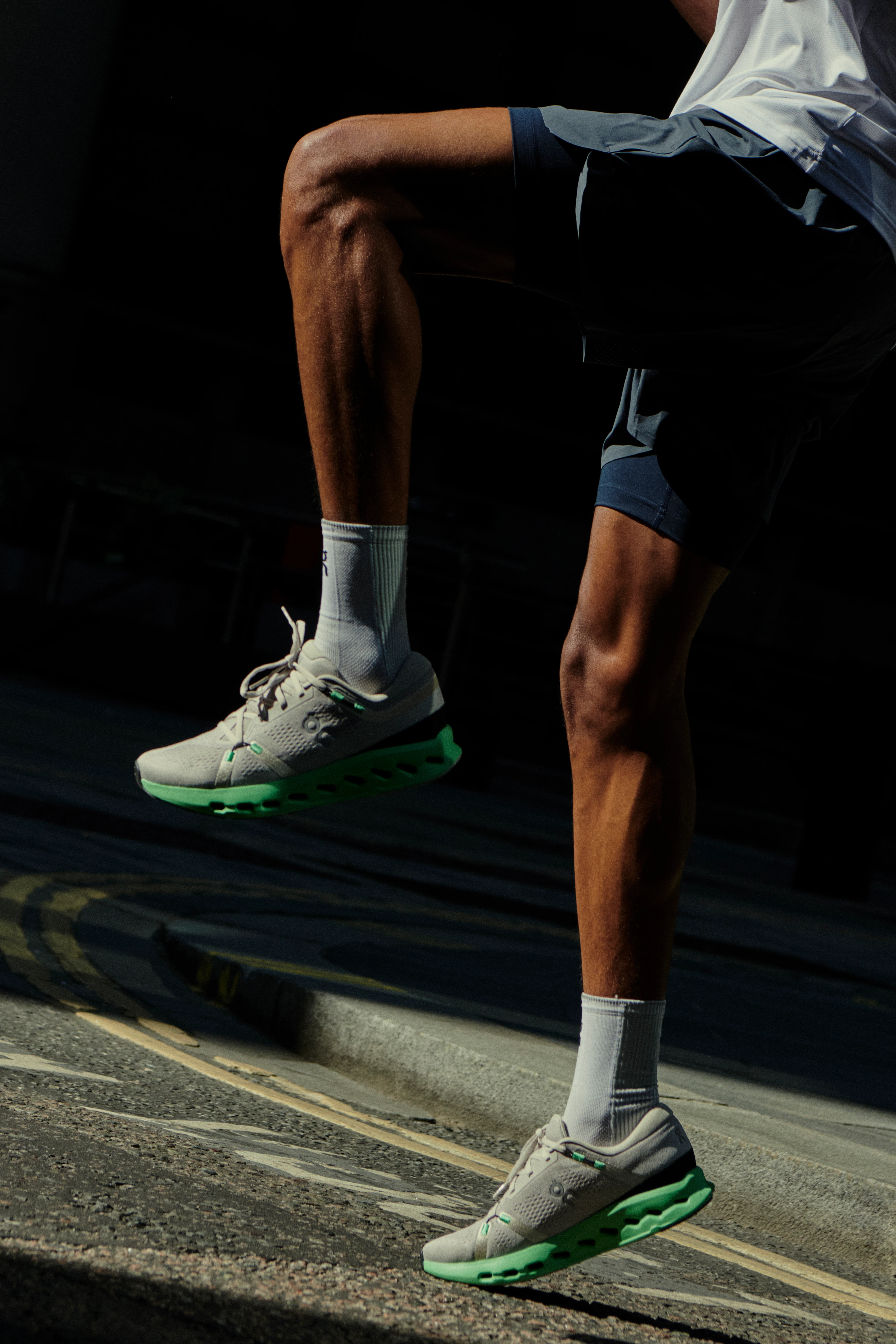 La parte inferior de un runner haciendo un ejercicio de rodillas elevadas para calentar. 