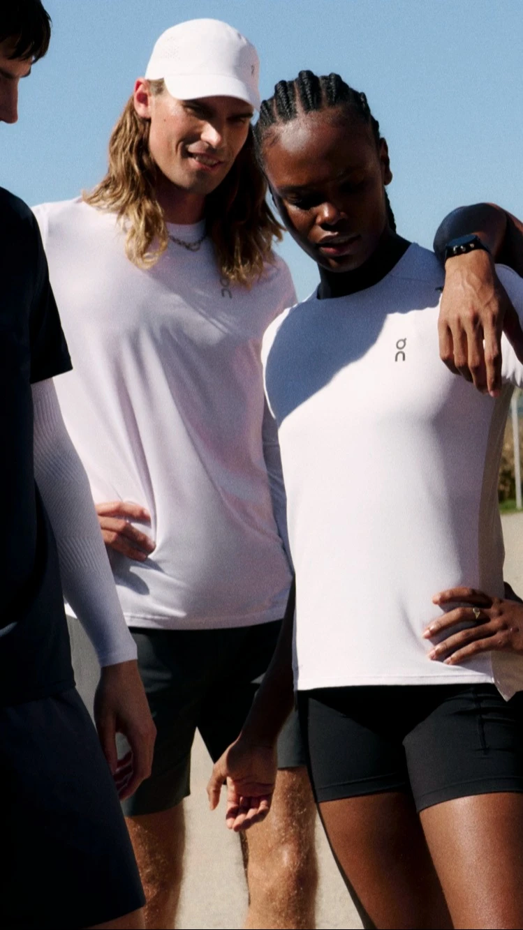 Four runners taking a rest, one leaning on the other. 