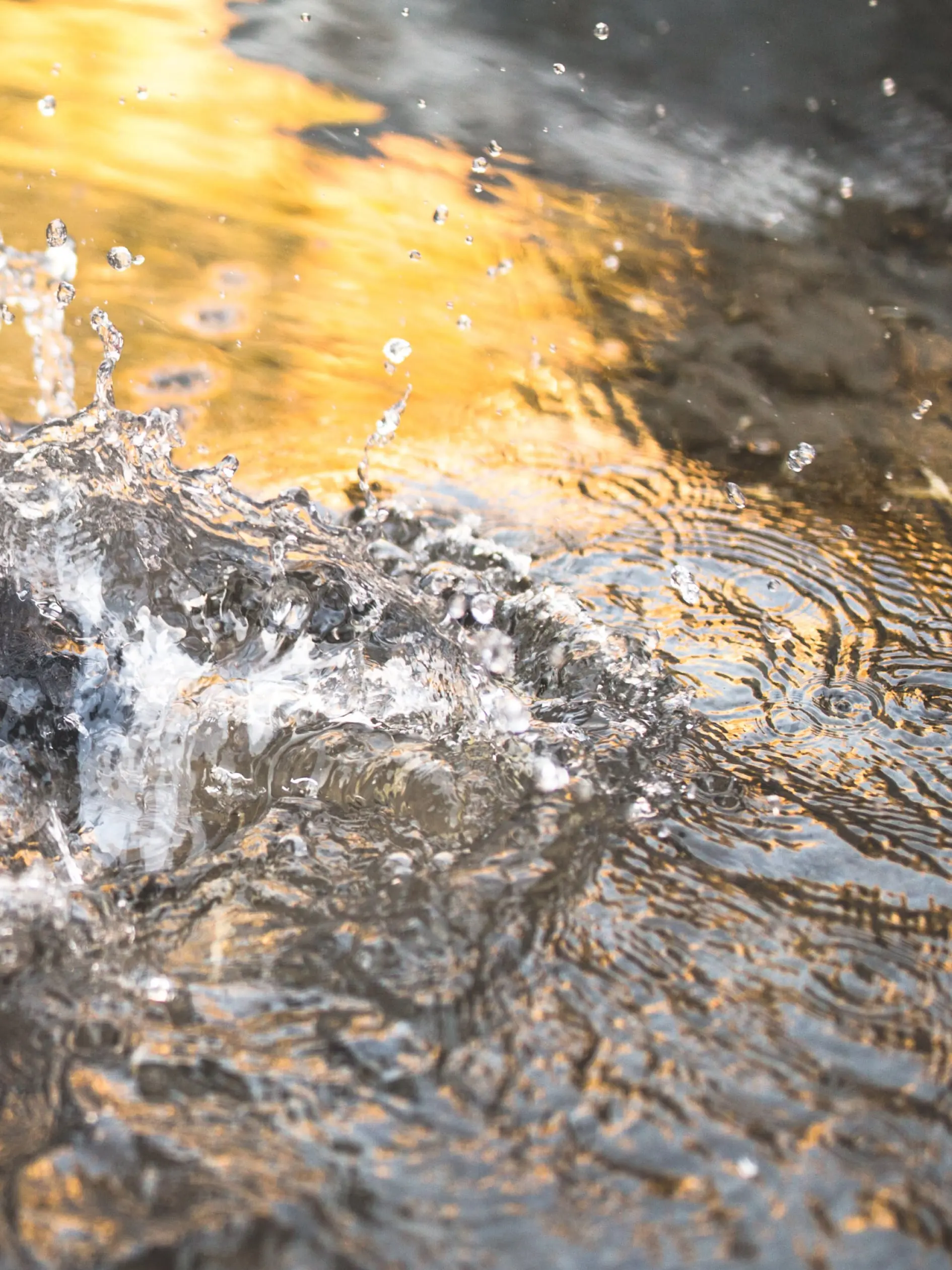 Close-up of a puddle with a bright yellow light reflection. 