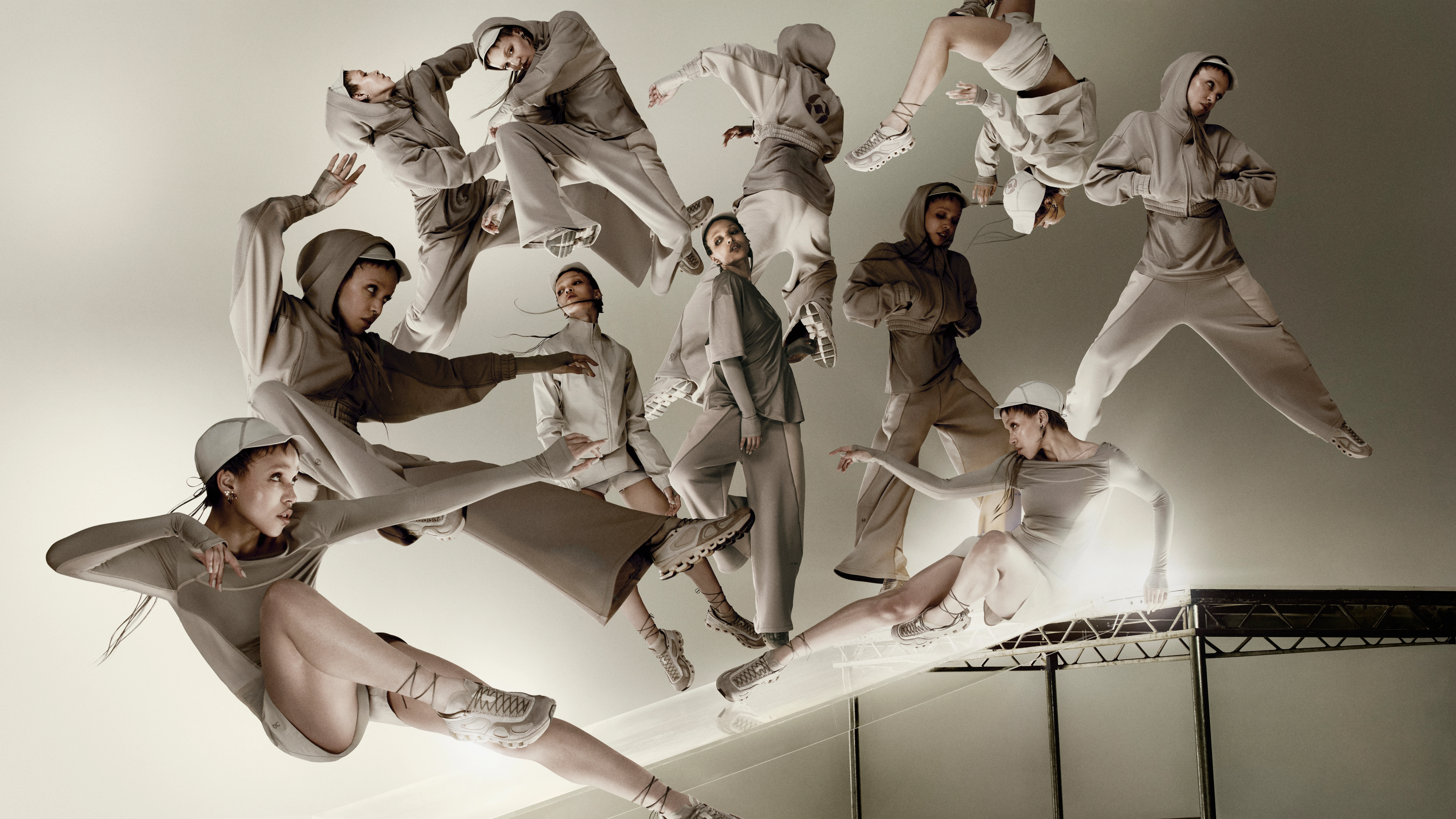 Eine dynamische Collage mit FKA Twigs in verschiedenen Posen und beiger Kleidung aus ihrer On Capsule-Kollektion vor einem hellbeigen industriellen Hintergrund.
