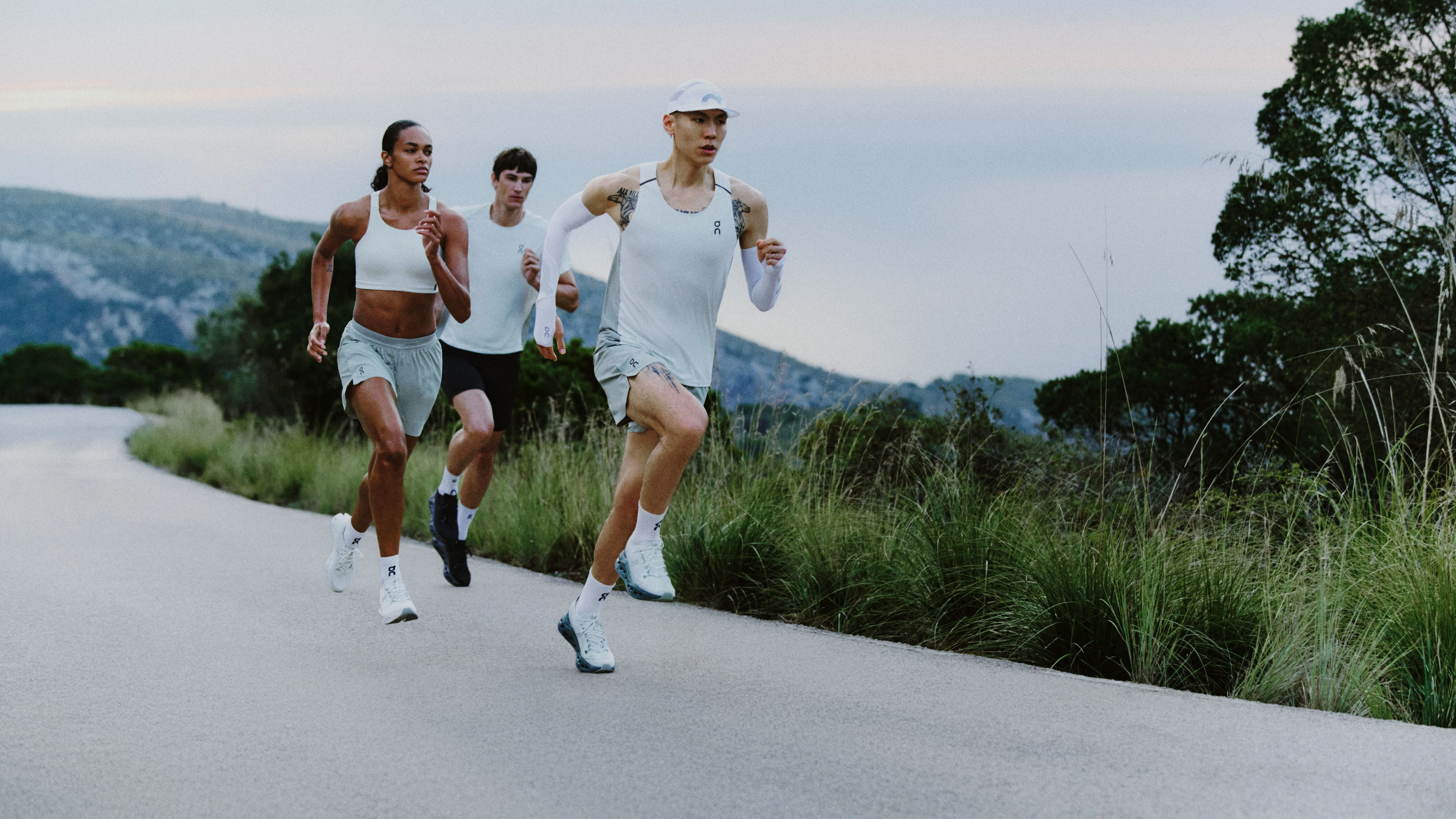 Trois runners en tenue On courant le long d'une route sinueuse.