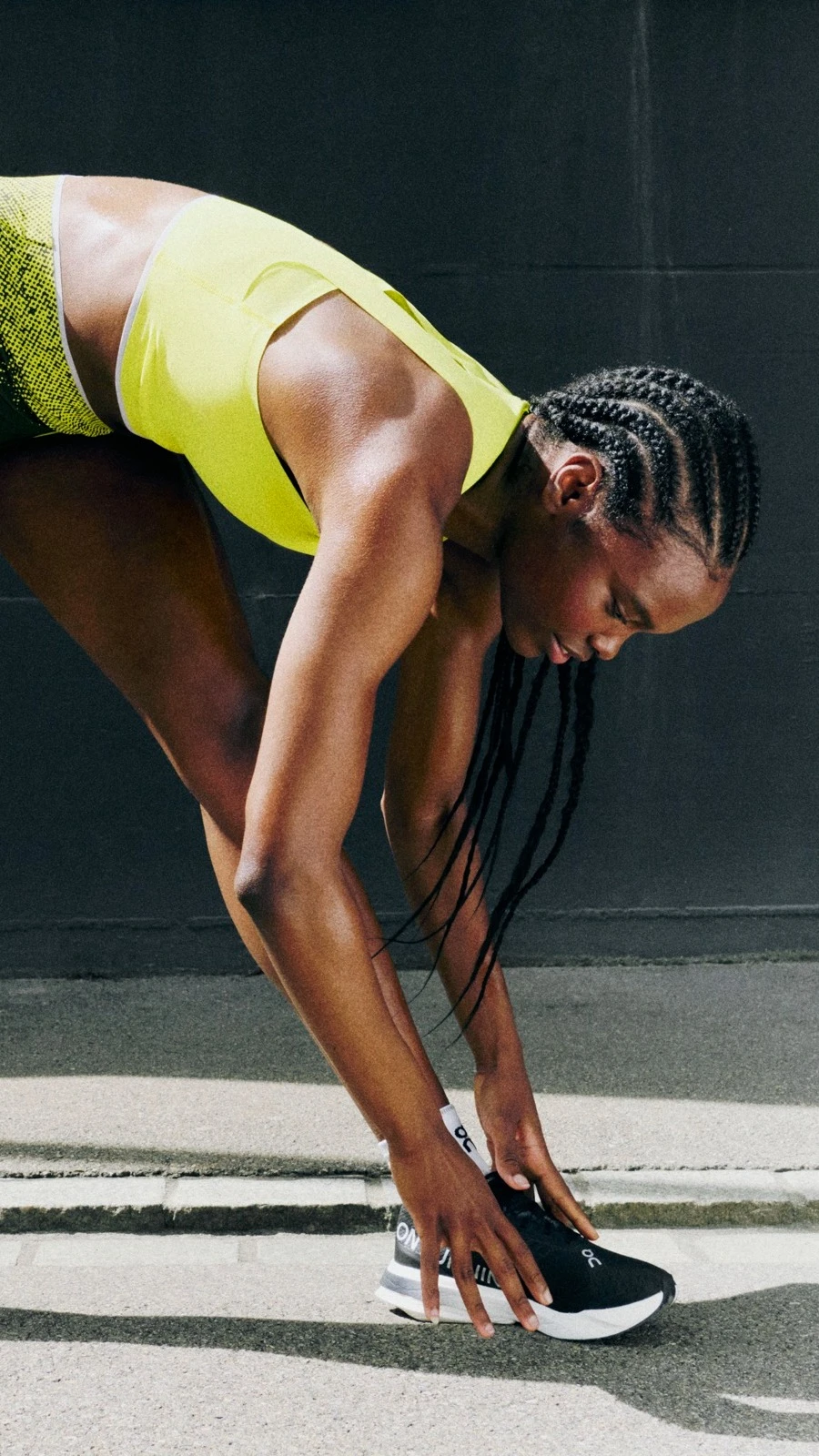 Una mujer inclinada sobre una pierna mientras se toca los dedos de los pies. 