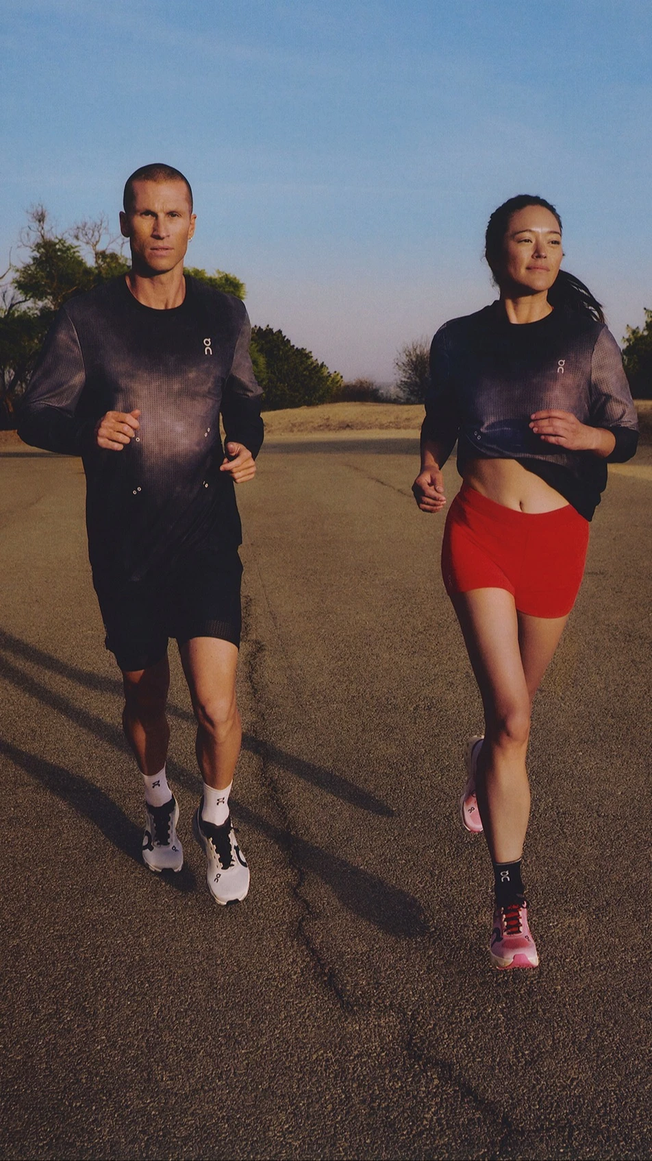 Cloudrunner를 착용하고 다양한 그라데이션을 착용하고 달리는 동안 휴식을 취하는 두 사람의 니다운 샷. 