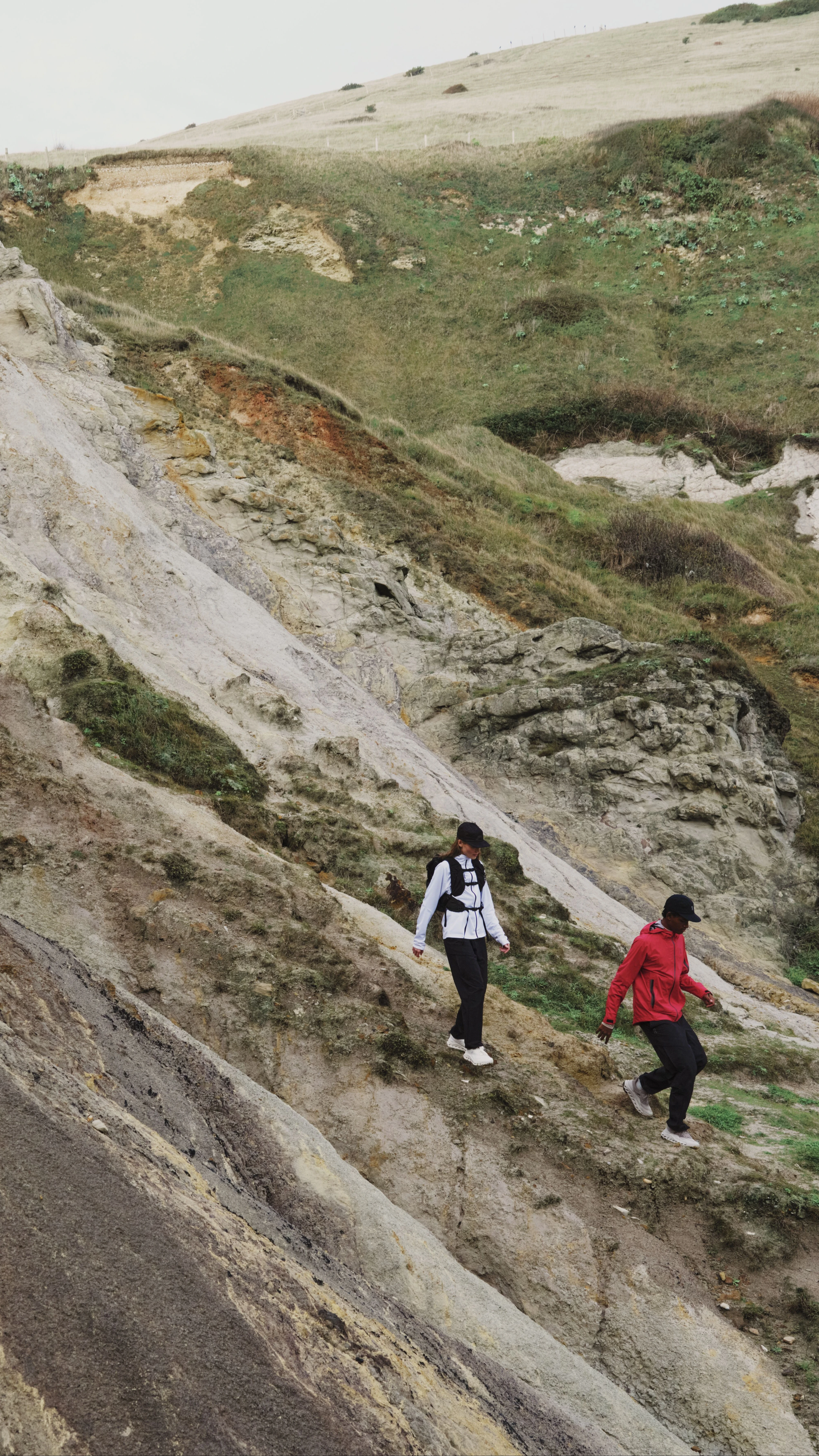 A pair of hikers at a distance, hiking along a ridgeline.