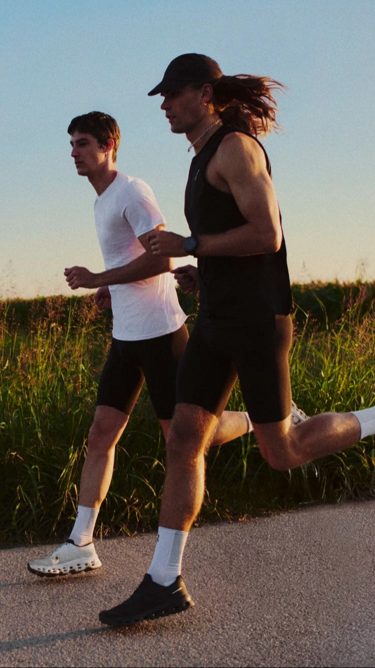Two runners side-by-side, running on a country road.