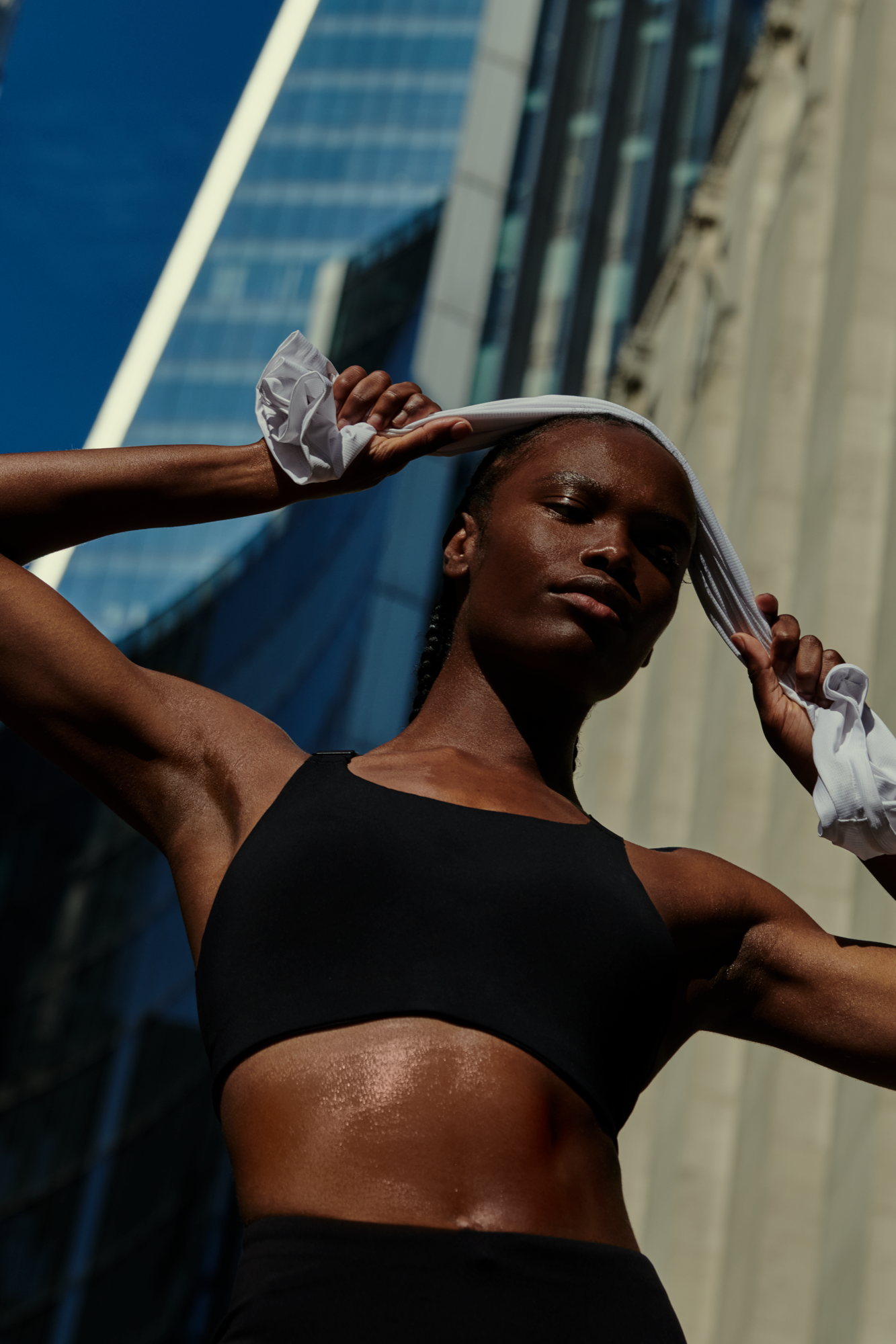 Donna che si asciuga il sudore dalla fronte dopo un allenamento all’aperto.