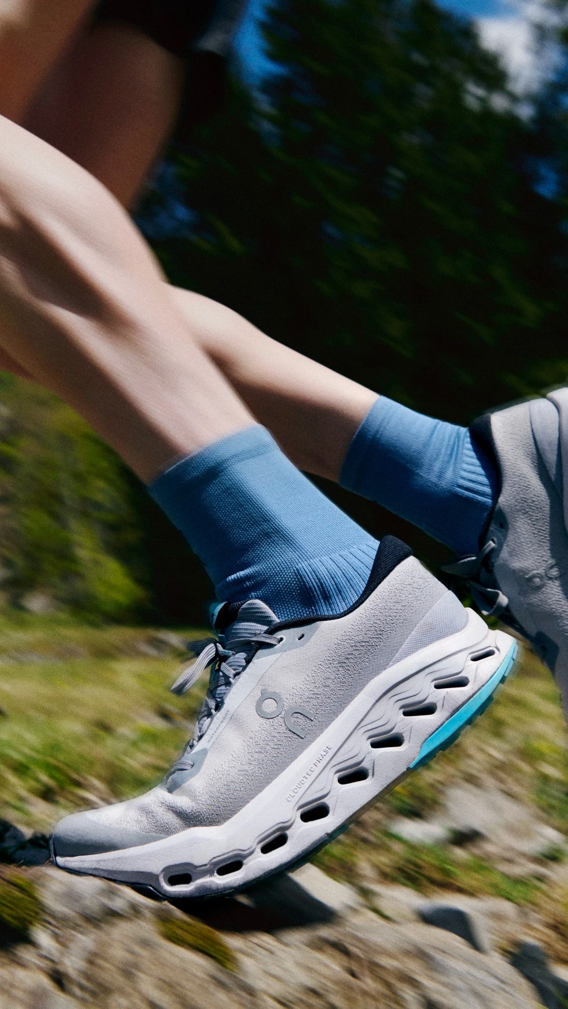 Close-up of On running shoes on a rocky mountain trail.