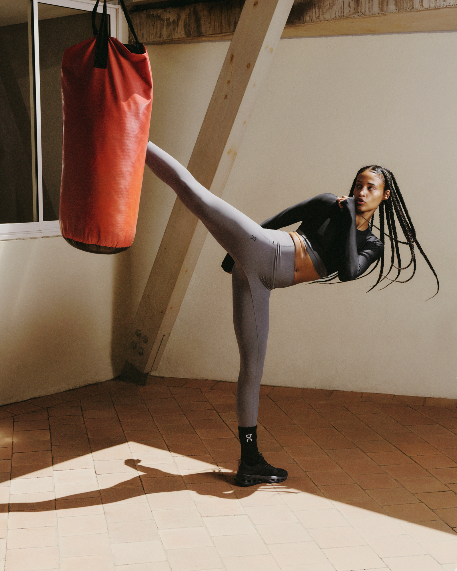 A woman kicking a punching bag.