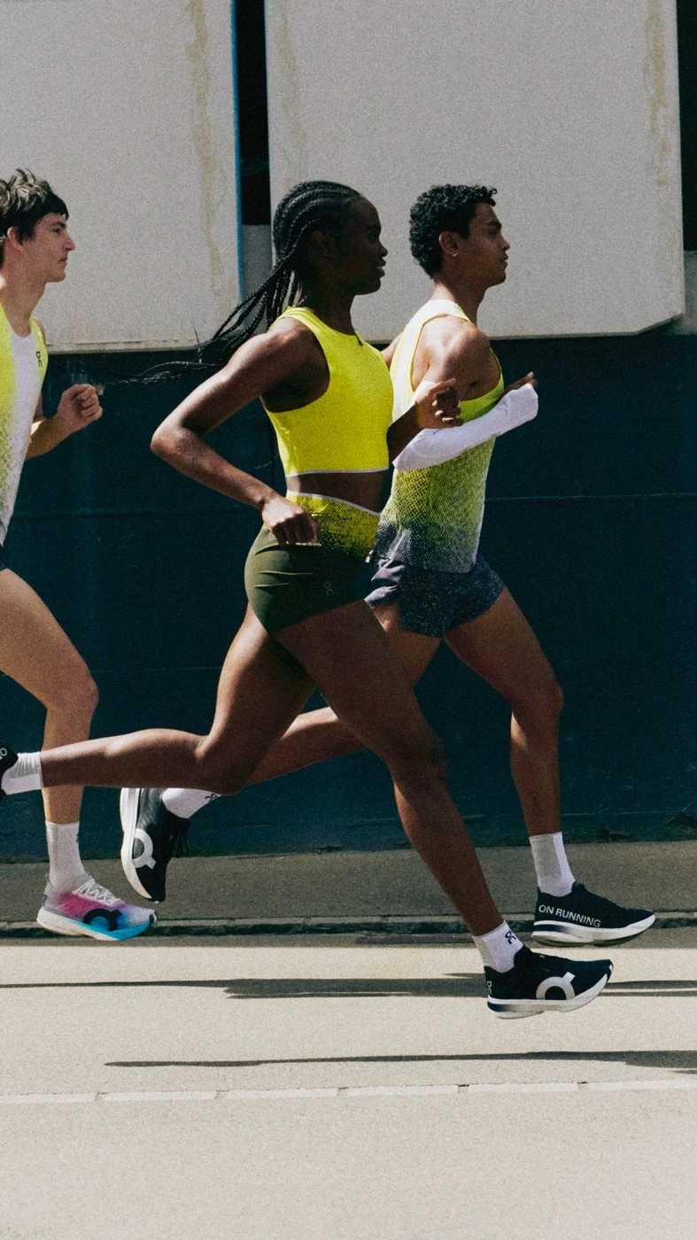 Three people mid-stride running on the road.