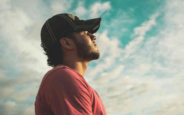Man outdoors looking calm and relaxing.