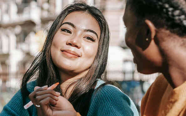 Two women talking and smiling together outdoors.
