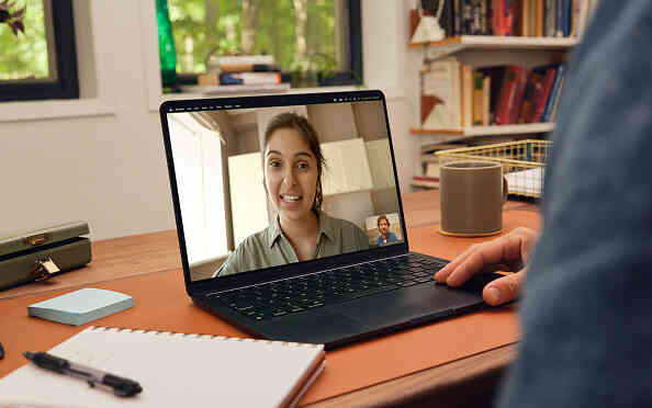 Therapist video call on laptop at home desk.