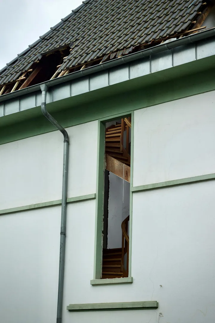 Damaged residential roof exterior photographed for storm-damage documentation.