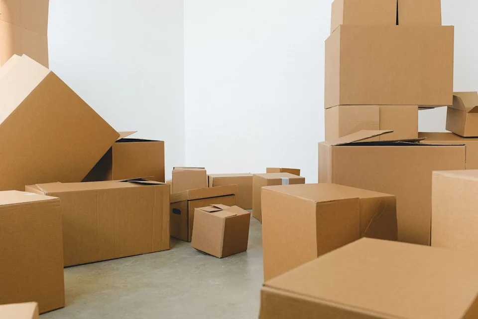 Plain cardboard packing boxes arranged on the floor of an empty room