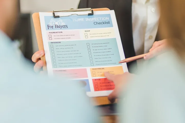 Hands reviewing a home inspection checklist on a clipboard