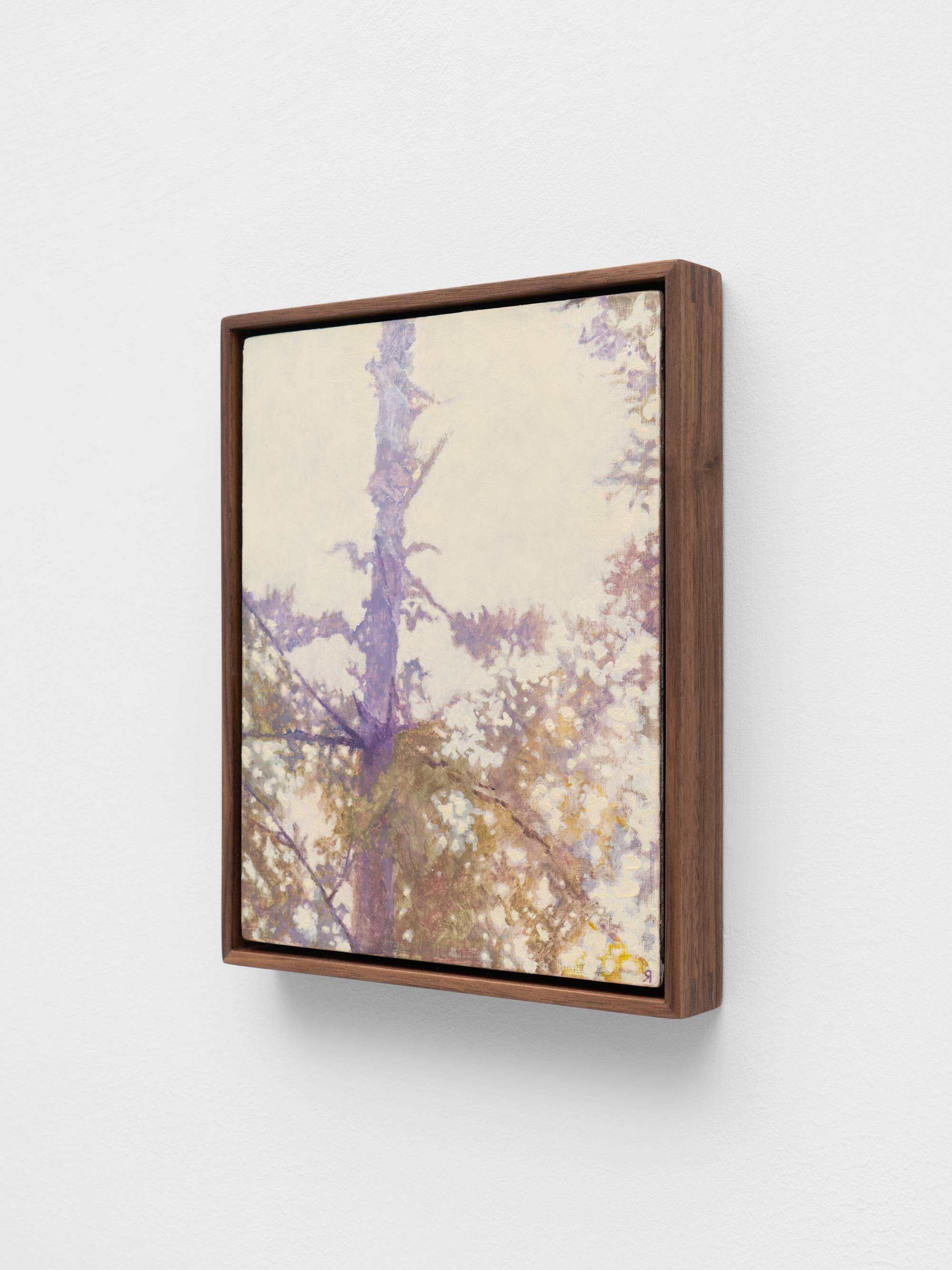 A painting framed in dark wood depicts the trunk and branches of a tree against a light, hazy background. The artwork uses soft brushstrokes and a muted color palette with hints of purple, green, and white.