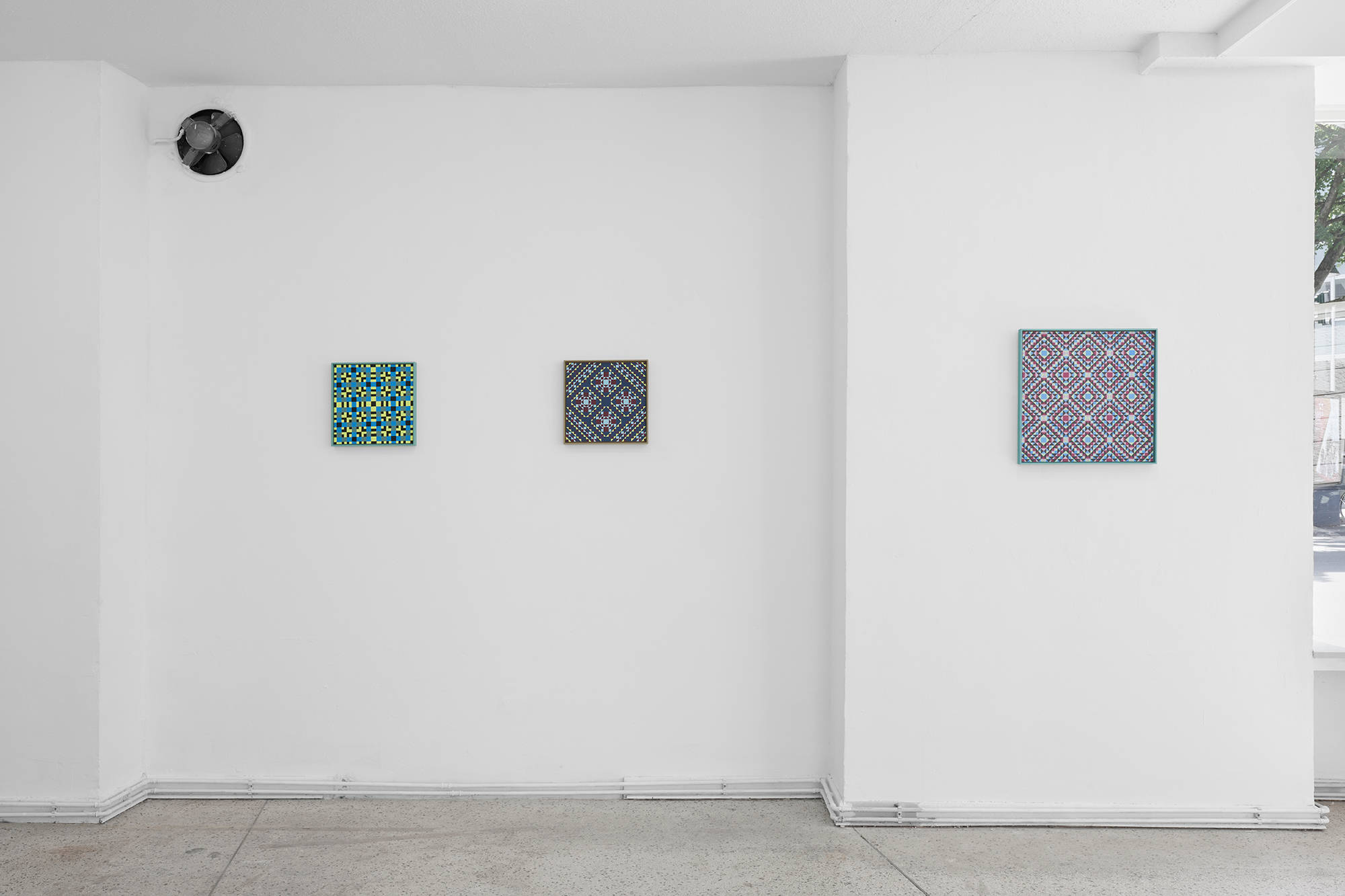 Three paintings are installed on a white wall.