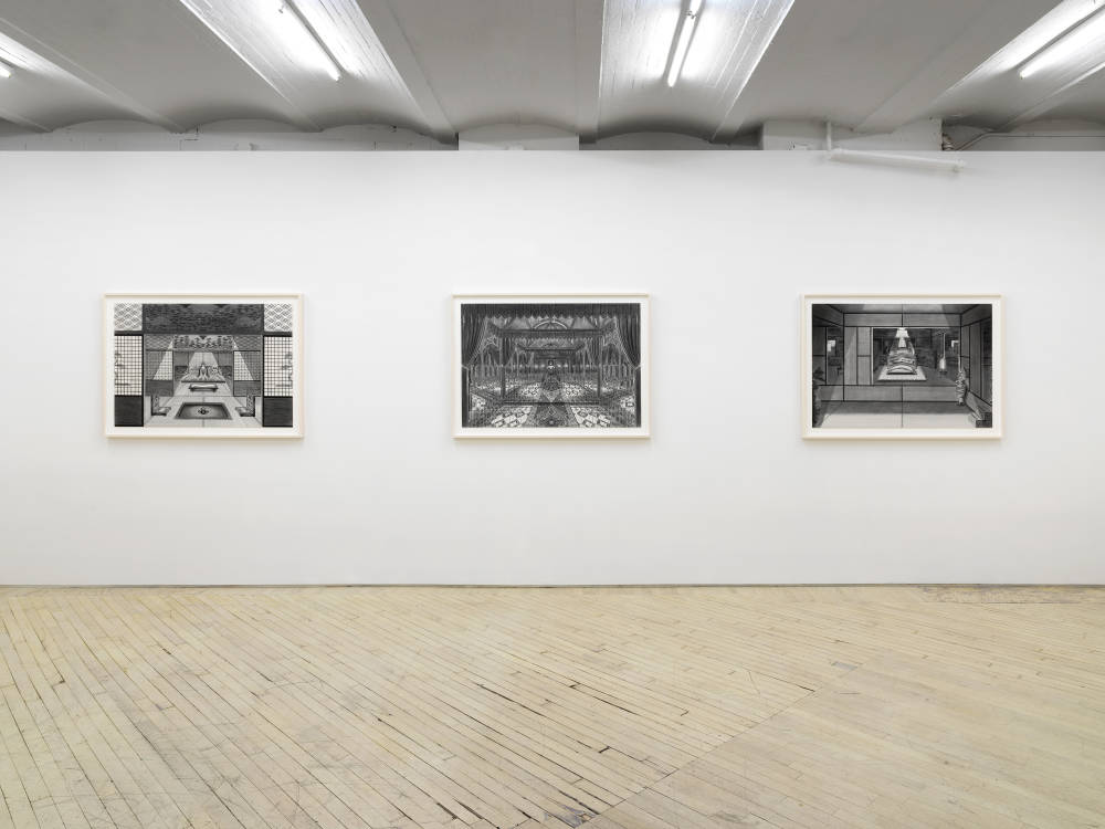 Three large ink and graphite drawings depicting intricate interior spaces hanging evenly spaced apart in off-white frames.