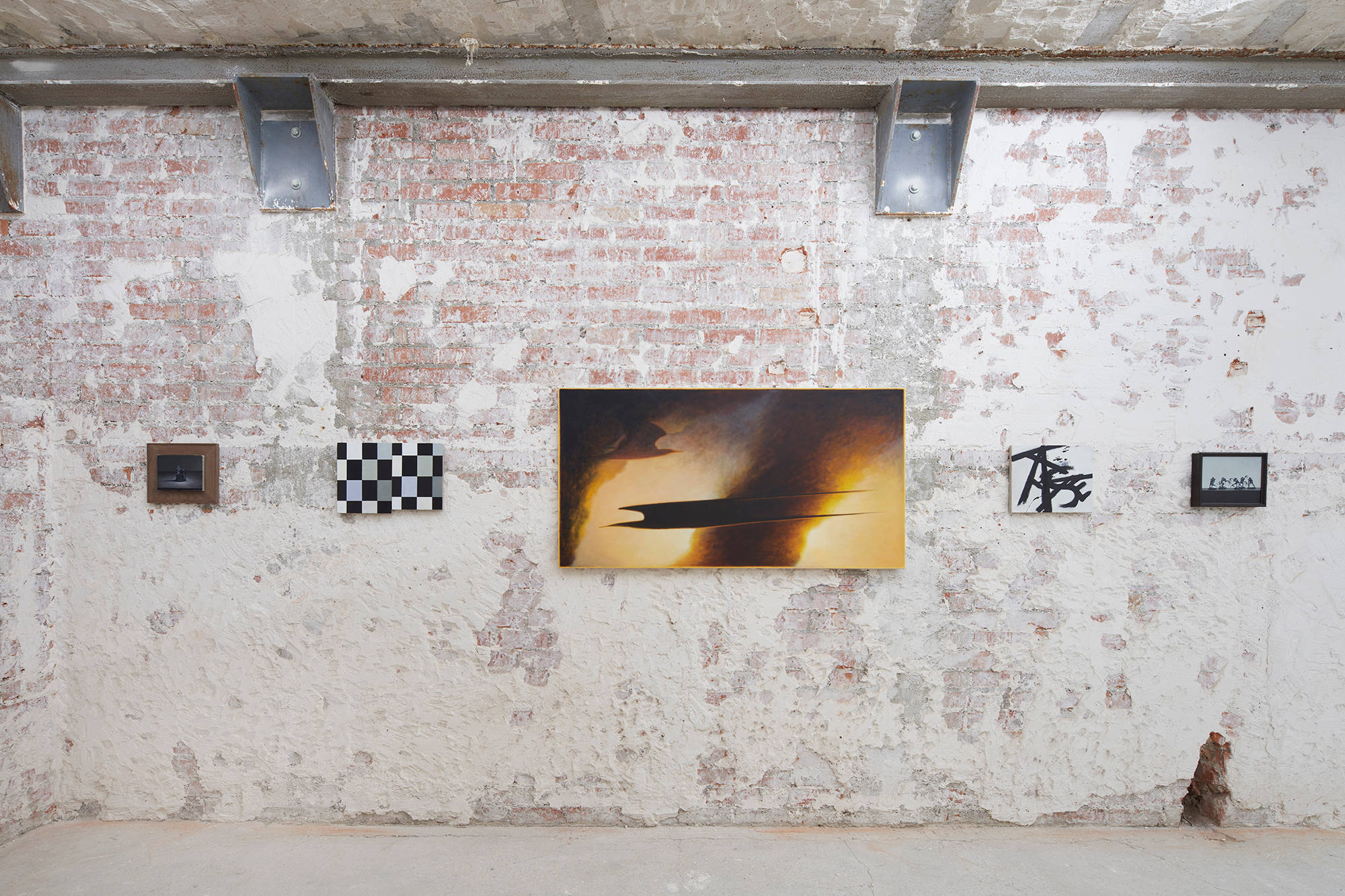 Installation view of Ian Miyamura paintings at the Paris Internationale fair, with various sized paintings hanging on brick walls.