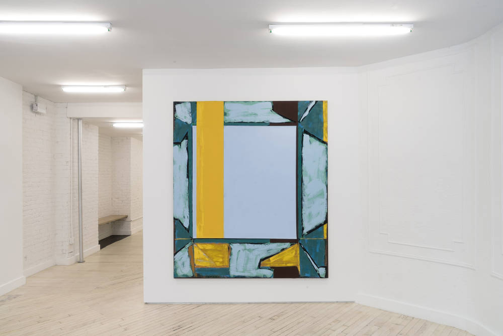Photo of the front gallery, straight on, showing a large abstract painting on the center wall. The painting has a central light blue rectangle, with a bright, thick honey yellow strip down the middle to the left side. The edges are painted roughly in light blues, turquoise, more yellow, brown and black.