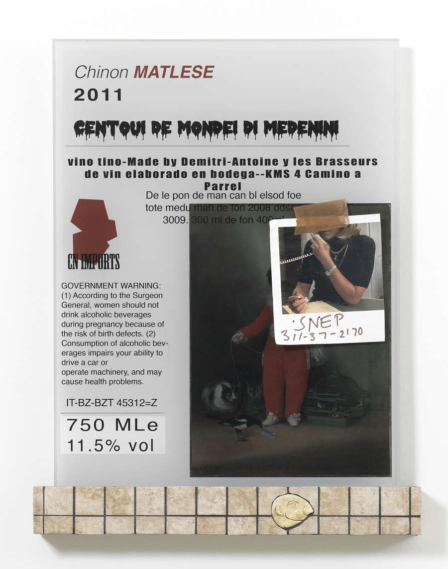 A sculpture hung on a white wall. The top of the sculpture contains multiple images and texts which appear unrelated to one another. There is the date "2011." "Chinon MATLESE." There is a printed image of a person holding a telephone with the text "SNEP" below, above the numbers "311-37-2170." There is a Surgeon General warning for alcohol. At the bottom of the sculpture is a base made out of floor titles with a cartoon face relief in profile. 