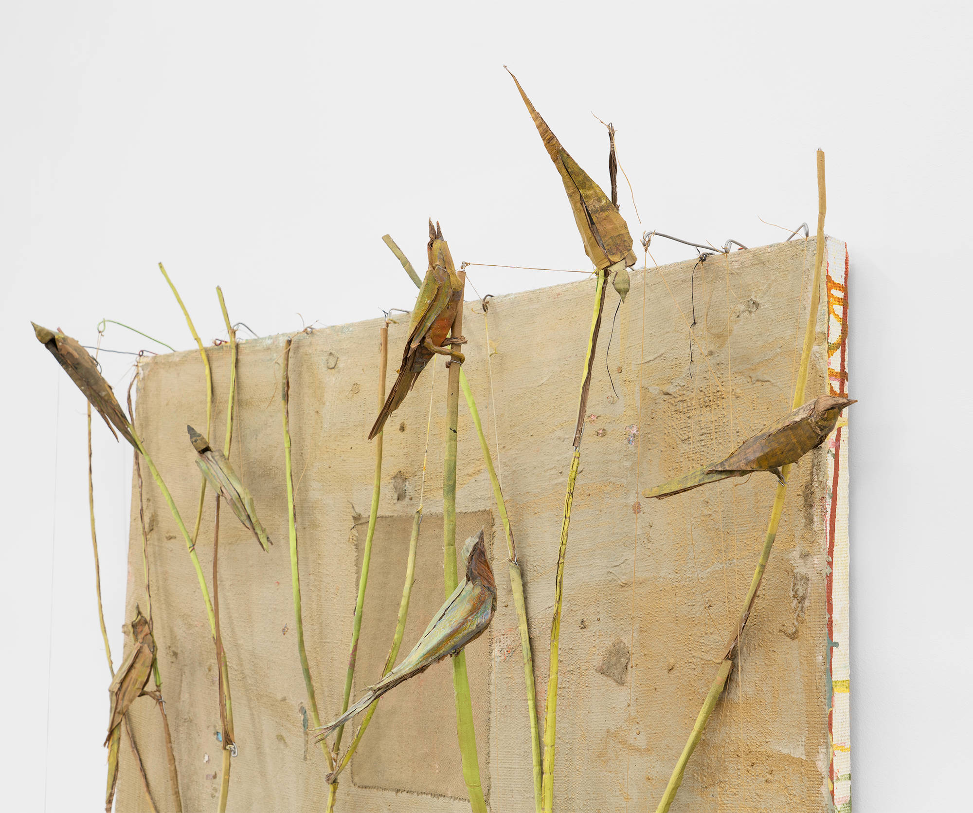 Detail shot of a large gold painting featuring a sculpture of a tree with birds by Tom Thayer.