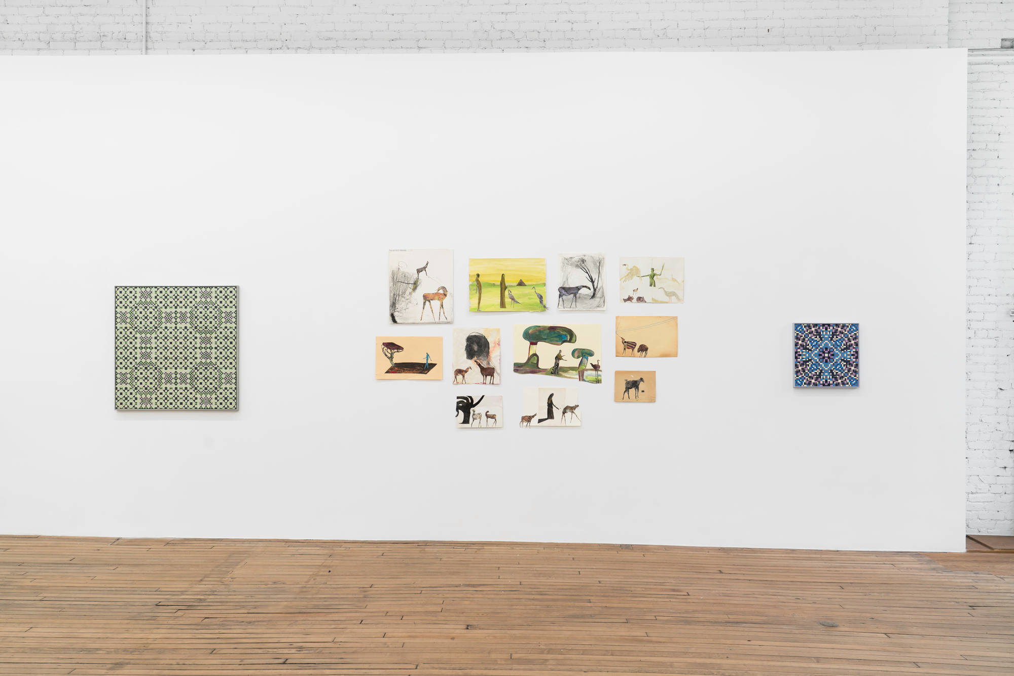 On the west wall of the gallery, 11 paper collage works by Tom Thayer hang, salon style, between two abstract paintings by Matt Hoyt.