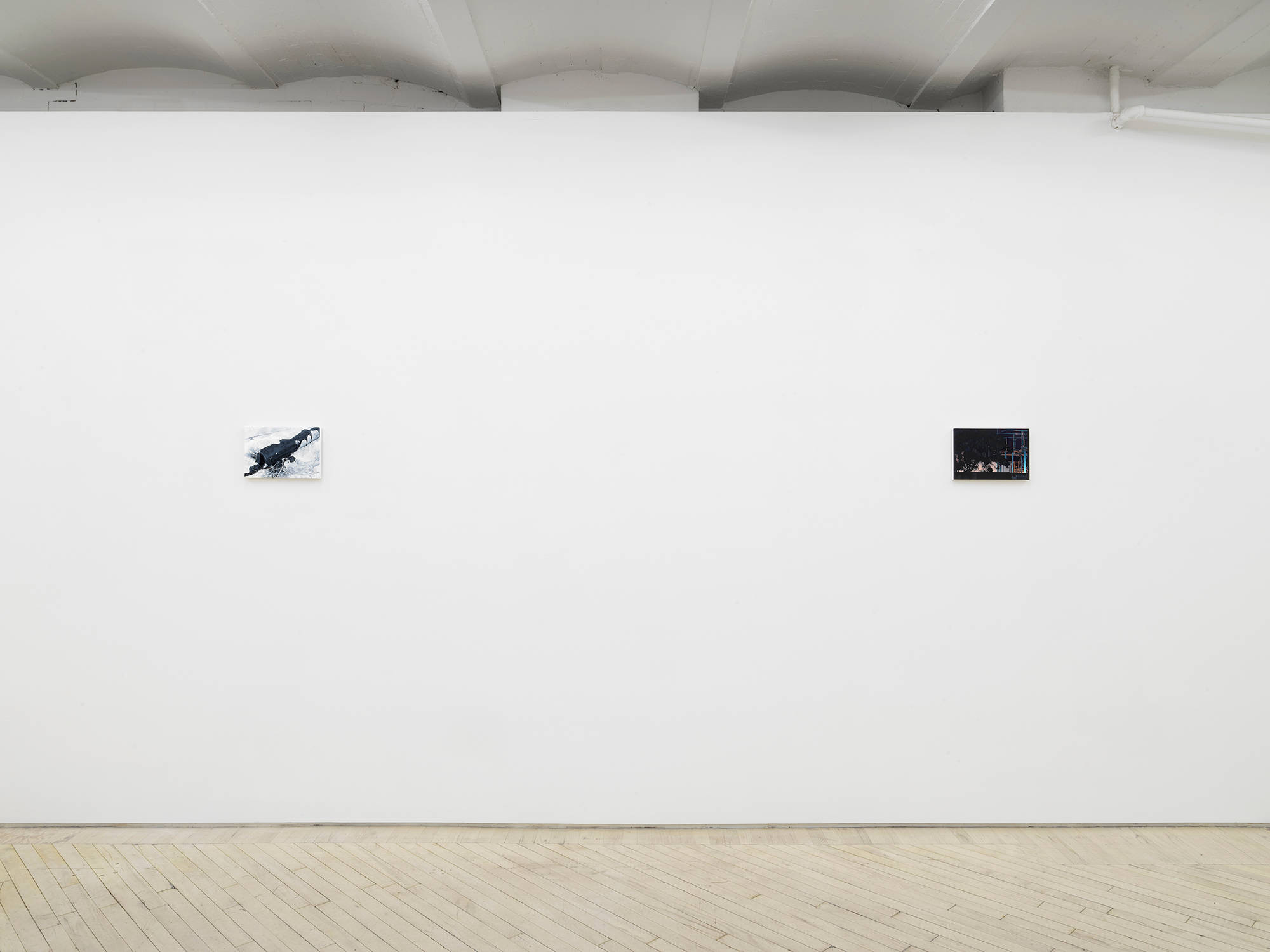 Installation view of an exhibition of paintings by Caleb Considine. Two small paintings hang on the walls of an art gallery.