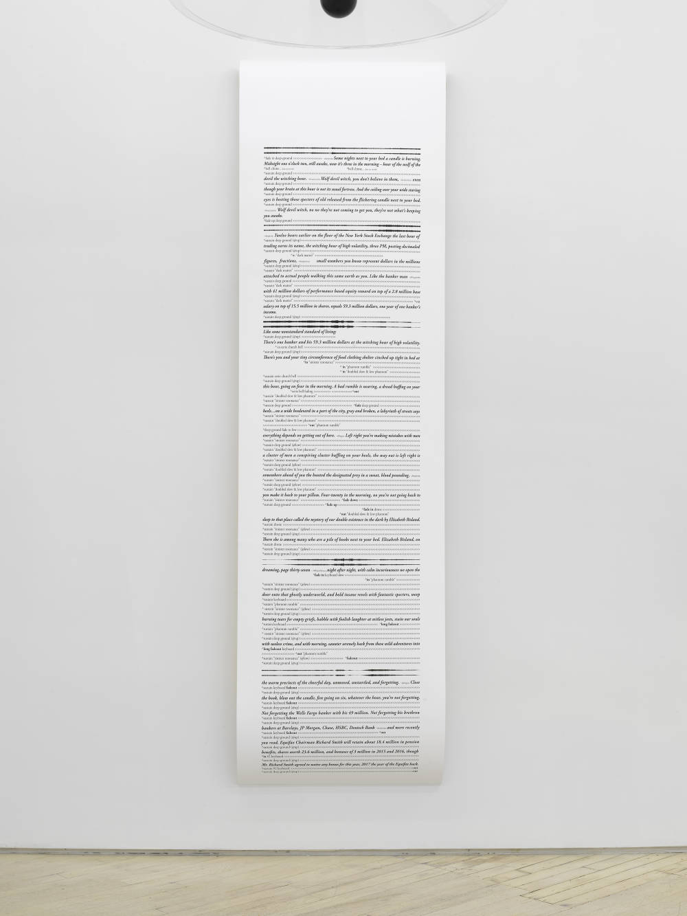 A large vertical scroll installed on a wall with black and white text.