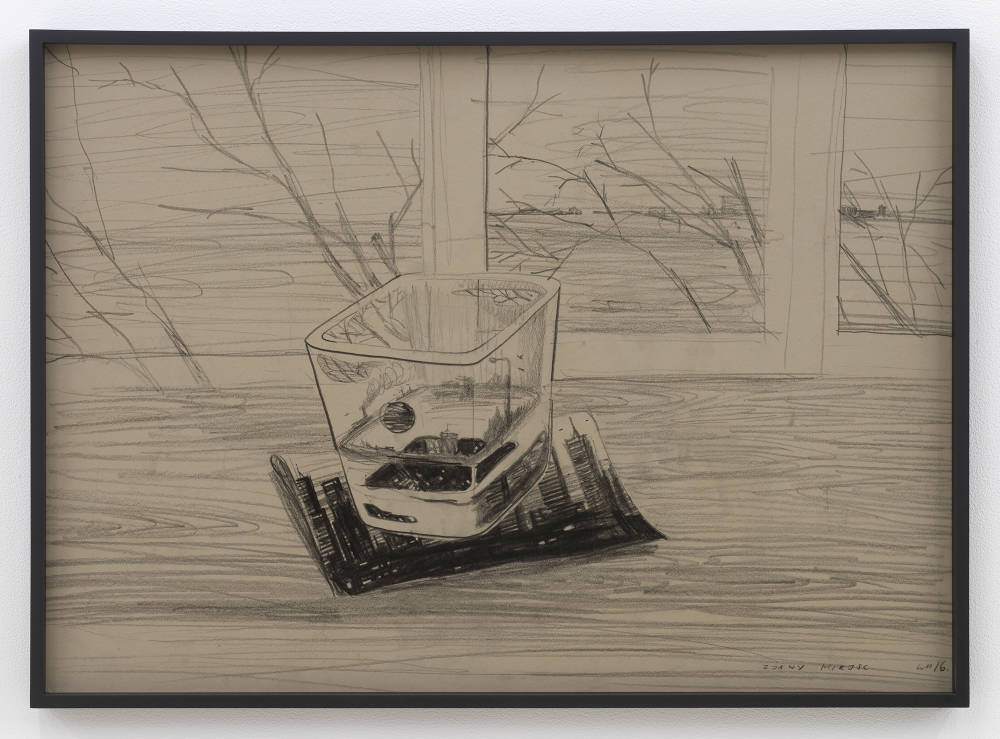 In a black frame, a pencil drawing depicting an abstract landscape resembling a dream world. The drawing in behind tinted glass. 