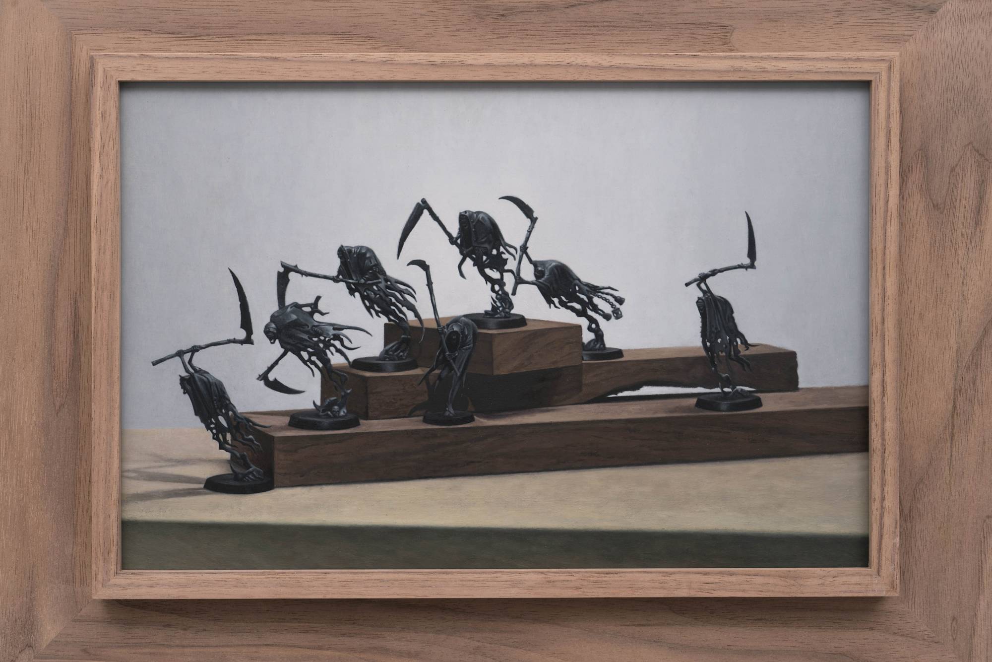 Detail view of Ian Miyamura painting depicting seven unpainted Warhammer figures against a light grey background arranged on 3 tiers of wood blocks.