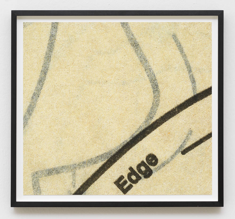 Image of a photograph in a black frame, the photograph depicts an up close look at a vintage sewing pattern. The pattern's paper is yellowed and coarse, and the lines are black. The pattern is cropped and all that is visible are a series of curved lines and the word "Edge."