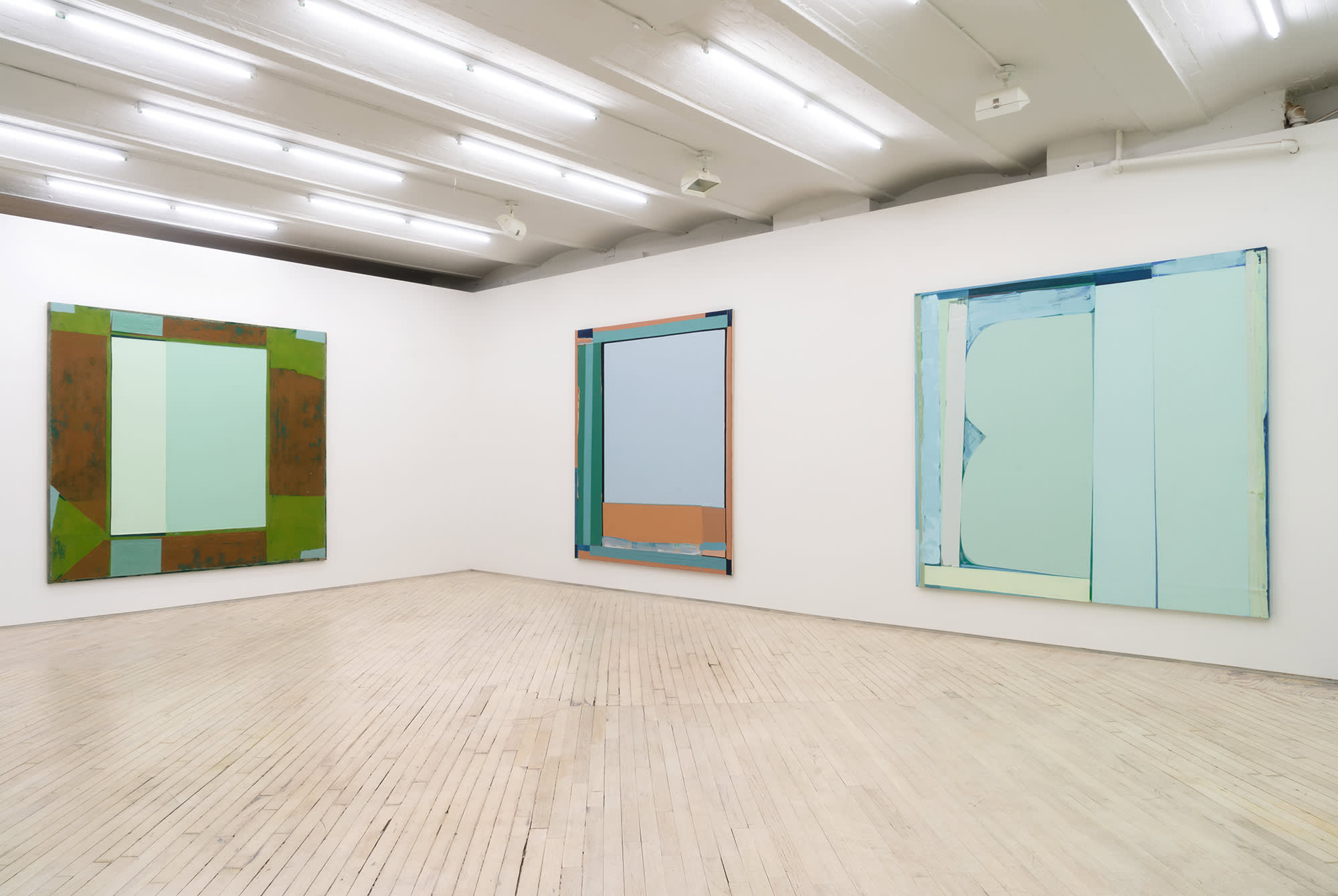 Corner shot of the main gallery. Three large abstract paintings hang in tones of greens, browns and blues.