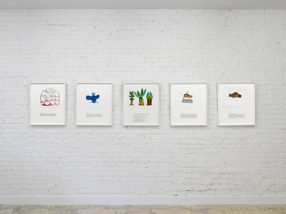 An installation of 5 colorful ink drawings on a brick wall. Each is framed in white with some black text below each drawing. From left to right there is a pink composition with a rain cloud and waves, a blue bird/bat, three green leafy trees with brown stalks, a brown hand writing a schematic drawing and two hands, one brown one grey, interlocked.