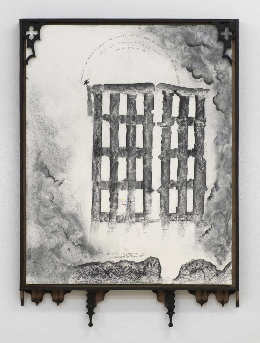 Black and white drawing framed in an ornate black frame on a wall. The greyscale drawing had a halo of clouds around the bottom left and upper and lower right, in the center is a ruin of an industrial building with many windows that appears to be glowing from inside. There is a circular arc of text along the top.