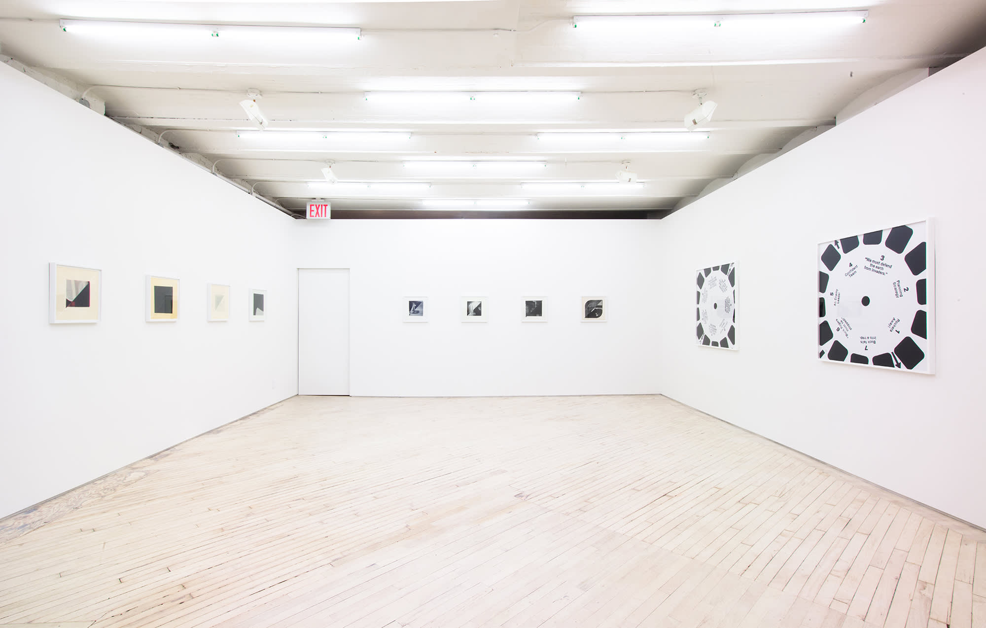 head on shot of the main gallery, four small photos on the left, 4 small photos on the back wall and 2 larger more graphic black and white pieces on the right.