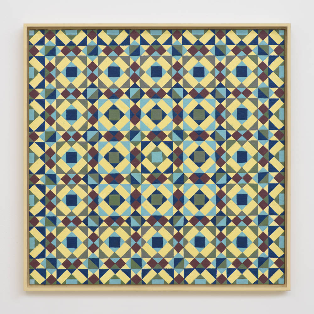 On a white wall a painting depicting a grid of crisscrossing lines generating many rectangles, and triangles. The dominant colors are hues of yellow, blue, and maroon. The frame is painted yellow. 
