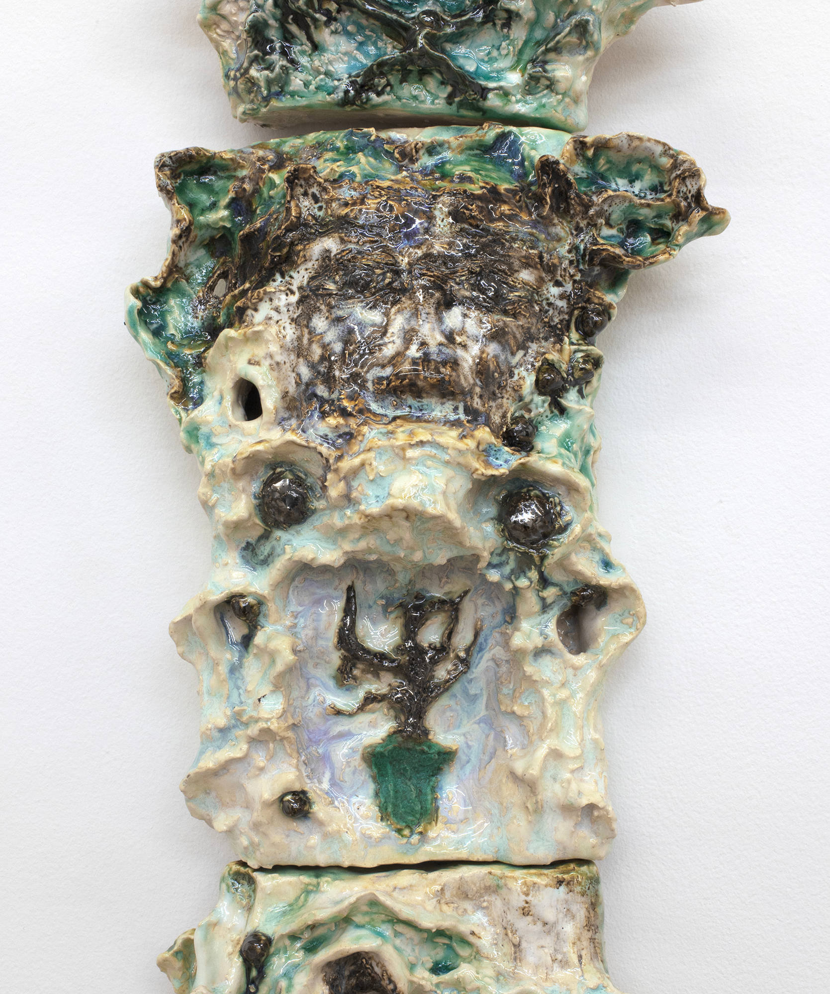 A tower of abstract ceramic sculptures installed in the shape of an expanding column.