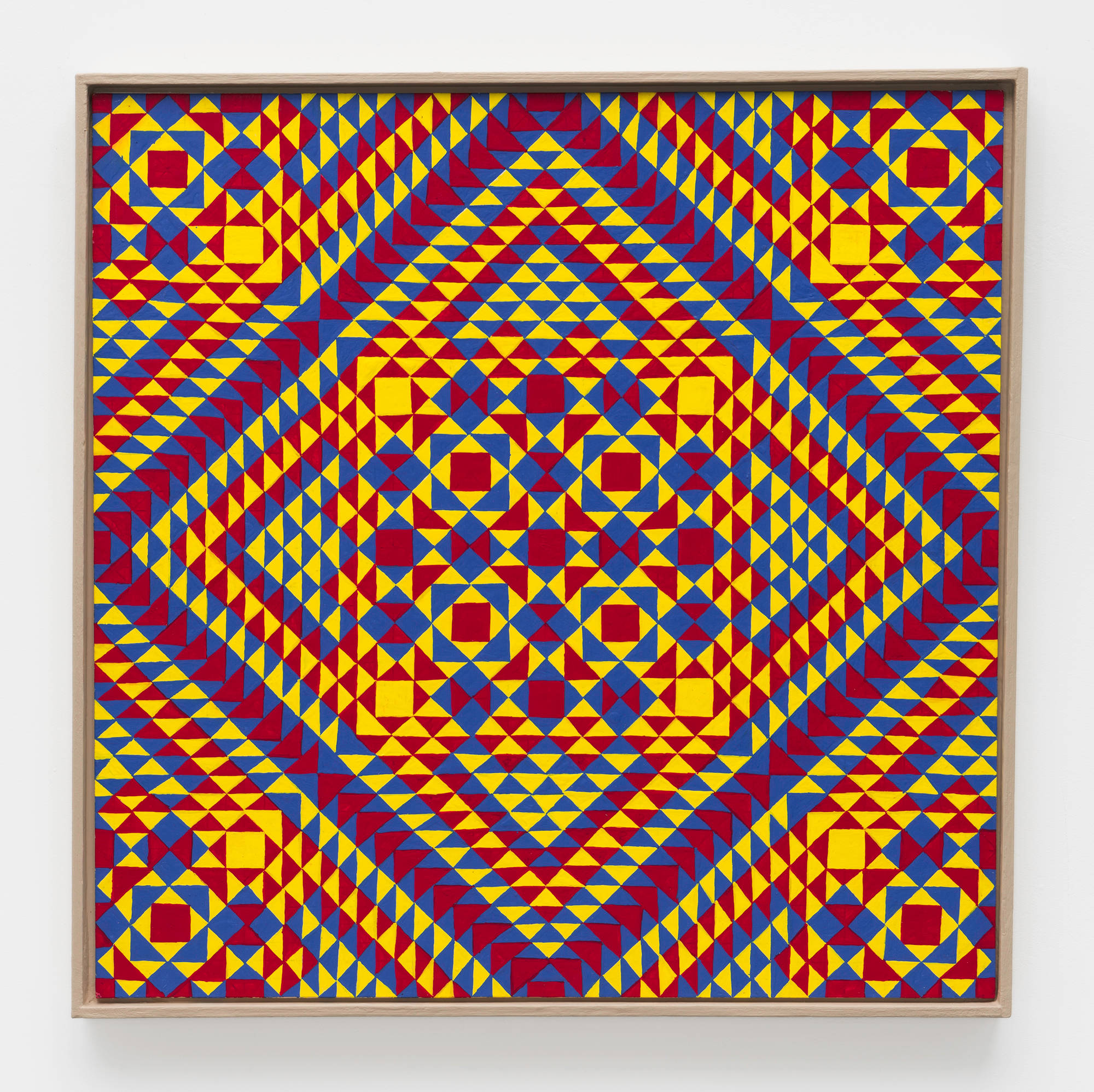 A colorful, symmetrical, geometric painting on board consisting of a pattern of repeating diamonds and triangles of yellow, red, and blue, in a tan artist frame.