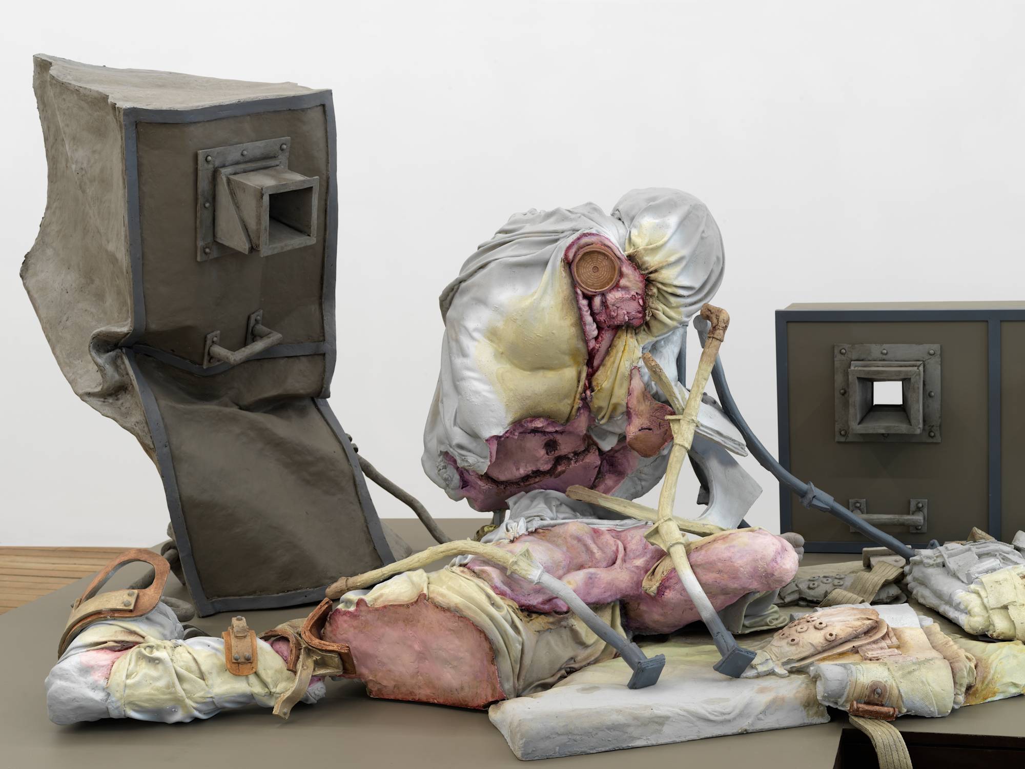 Close up image of a sculpture depicting abstracted human forms and structures that resemble cages.