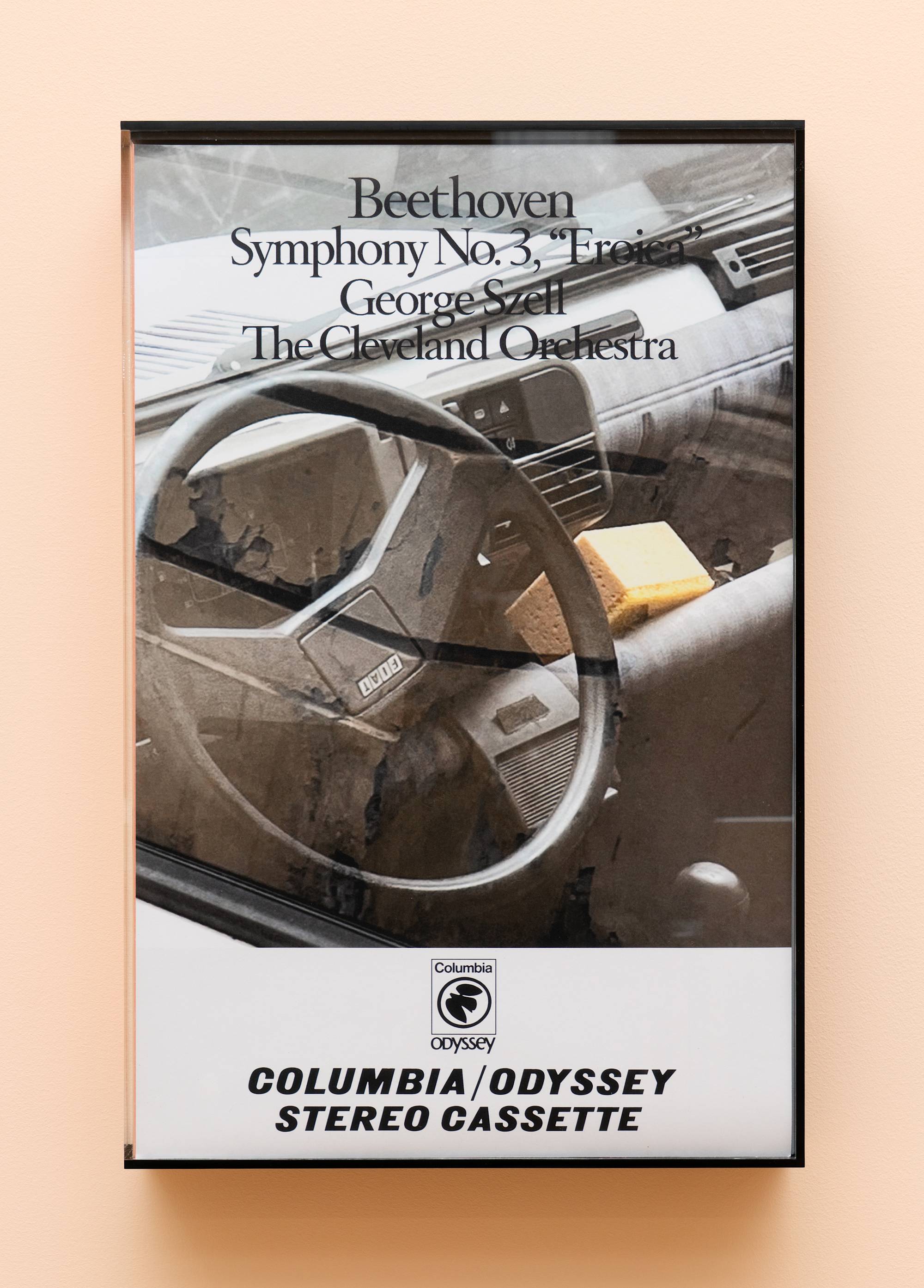 Oversized audio cassette case featuring an image of a car interior with a yellow sponge.