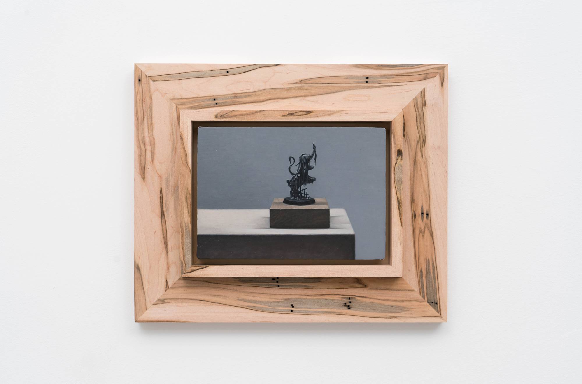 Ian Miyamura painting depicting an unpainted Warhammer figure sitting on a wood block against a grey background.
The painting is mounted to a wood frame made by the artist.
