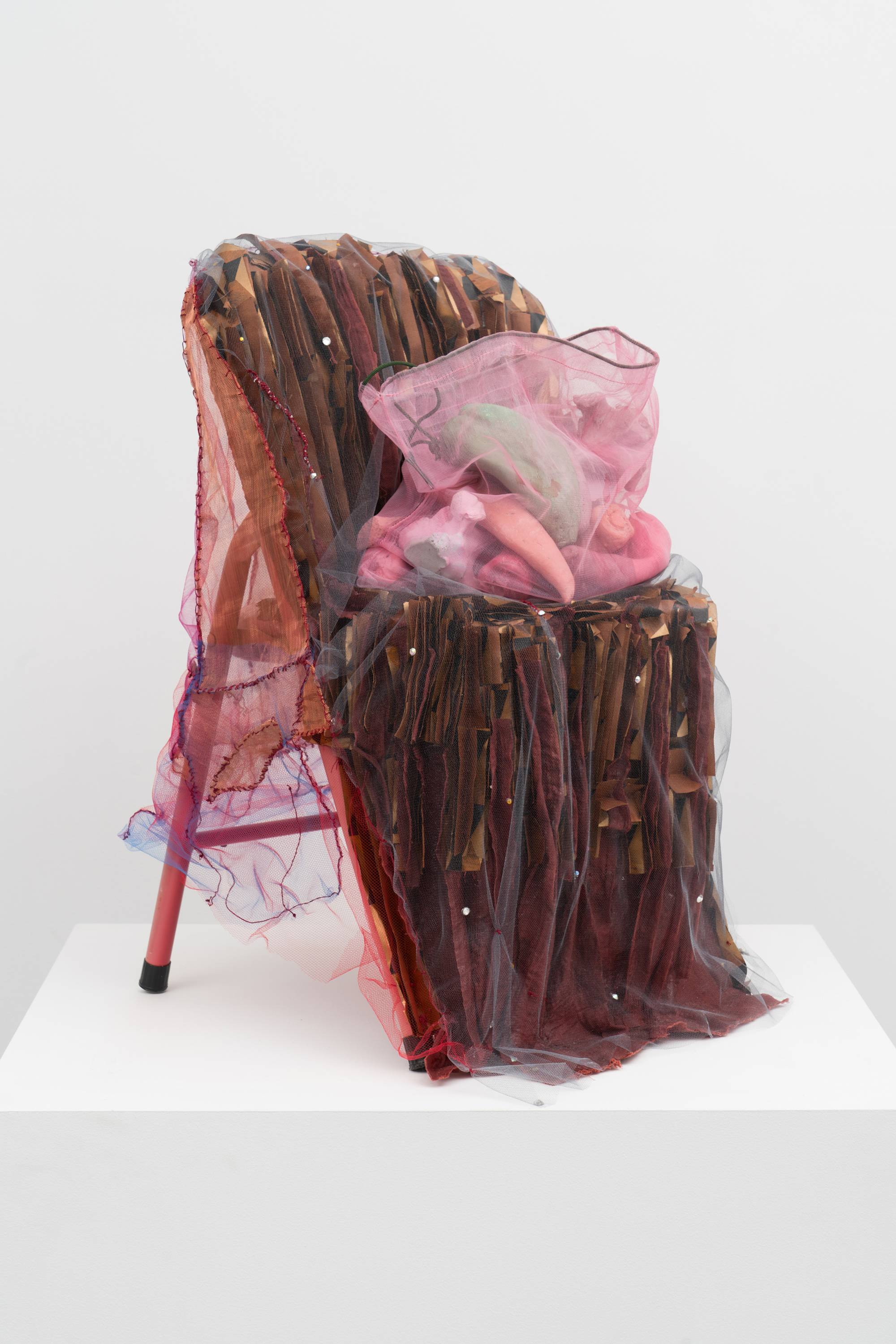 Em Rooney sculpture of a red children's folding chair adorned with mesh, folded paper, and resin-cast fruit.