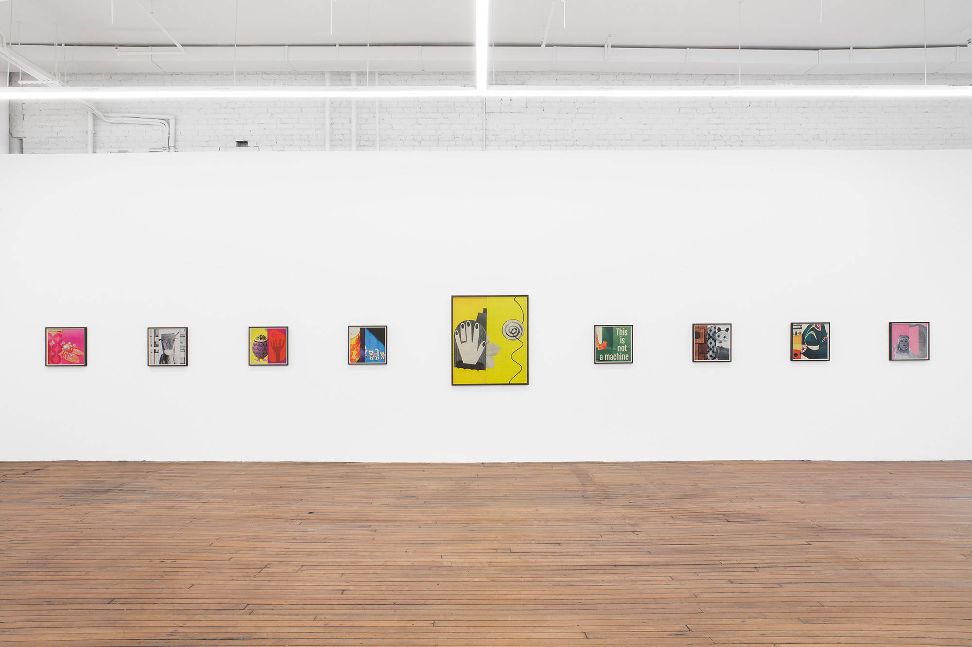 A large gallery space filled with evenly spaced colorful photographs in dark brown frames.