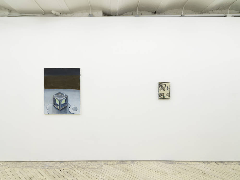 In a gallery space with white walls and wooden floors, two small paintings are hung evenly spaced apart. The painting on the left depicts a cubic form resembling an ice cube with a dark brownish-blue background. The painting on the right resembles an illustration. The dominant color is a warm white. The painting is in an irregularly shaped frame. 