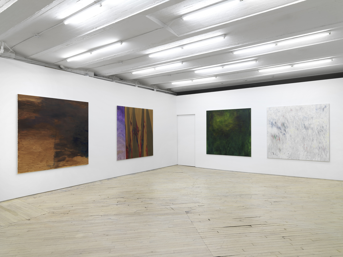 Four large, square, abstract paintings evenly spaced apart from one another in a large gallery space.