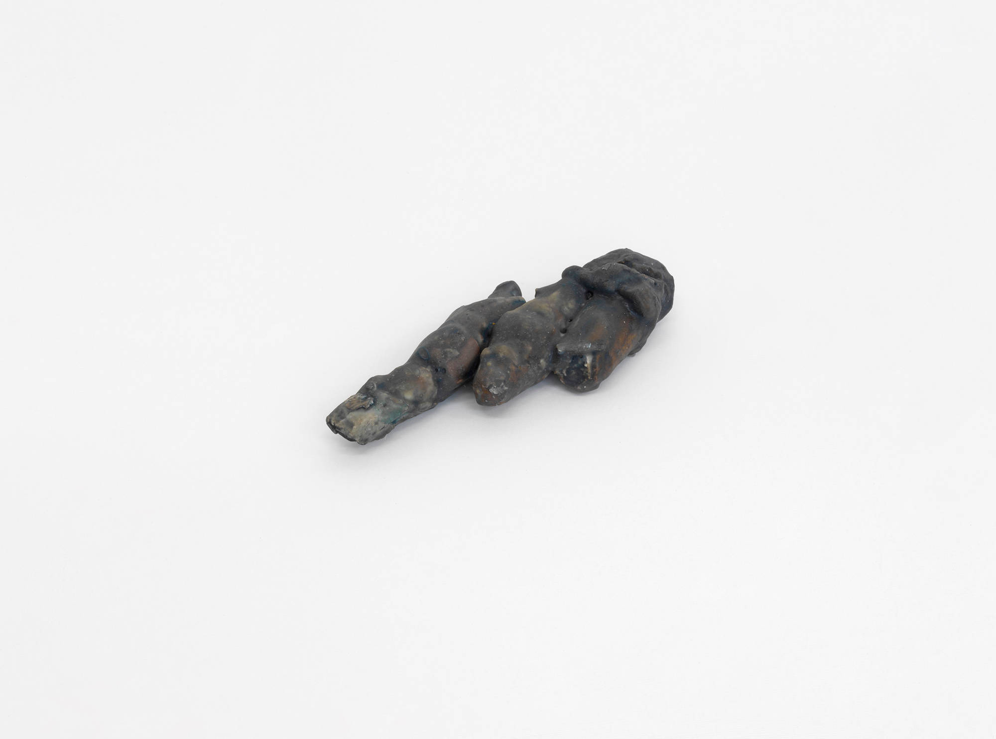 A small abstract sculpture resembling organic material . It is gray.
