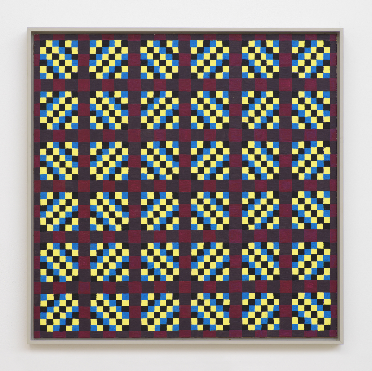 On a white wall a square painting depicting a grid of crisscrossing lines generating many rectangles, and triangles. The dominant colors are hues of maroon, black, blue, and yellow. The frame is painted gray. 
